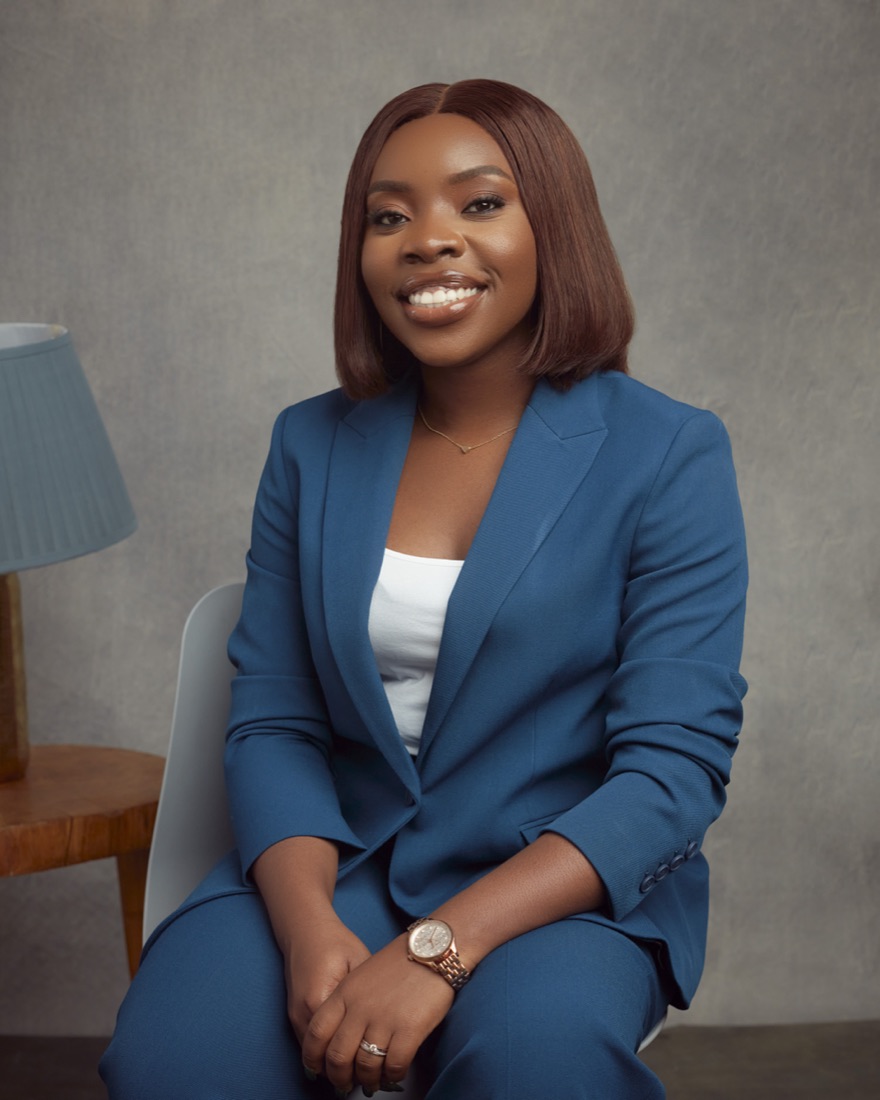 Chidera Peters smiling, seated in a blue suit